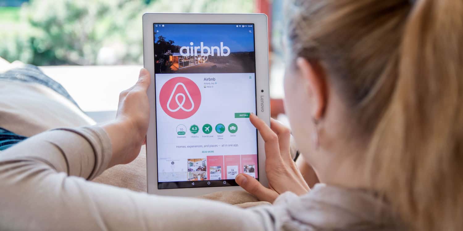 A woman is installing an Airbnb application on a tablet device.